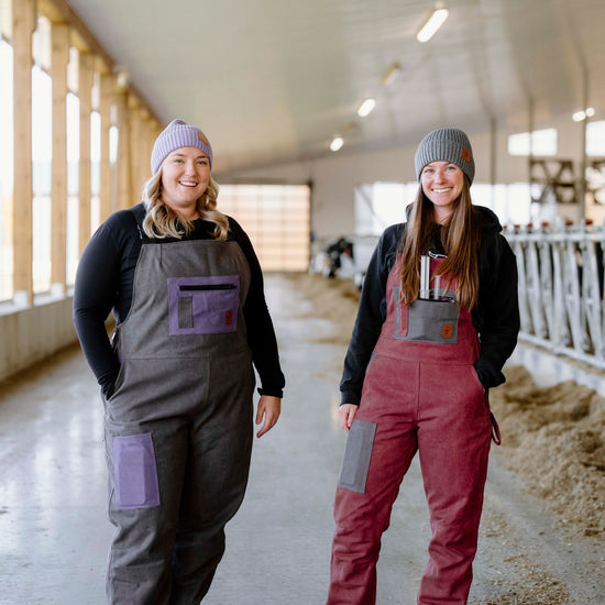 person wearing grey overalls with purple pockets beside other person wearing pink overalls with grey pockets 