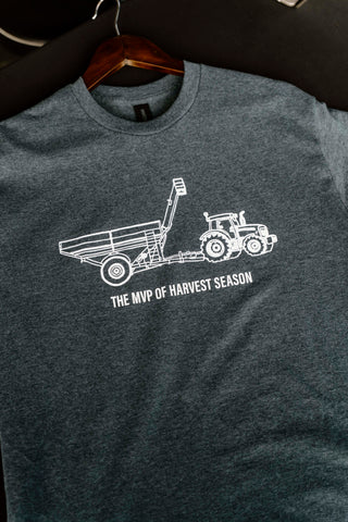 Gray t-shirt with white tractor graphic and text on a hanger against a dark background